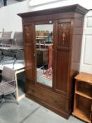 An Edwardian inlaid mahogany wardrobe with bevel mirror door