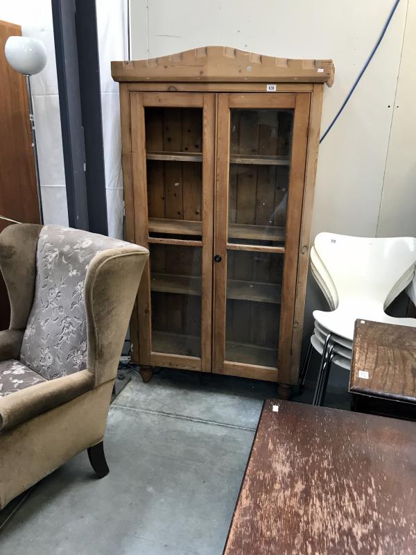 A pine cupboard with glazed doors - 1 glass panel missing