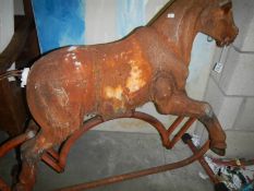 An old metal rocking horse, in distressed state.