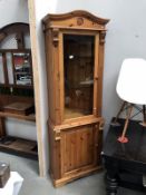 A solid pine corner unit with bevel glazed door panel and glass shelves