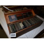 A wooden box containing approximately 110 black and white glass lantern slides,