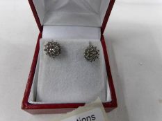 A pair of gold and diamond cluster ear studs.