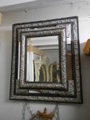 A 19th century French ebony mirror with gilt repousse' silver,, approximately 67 x 58 cm.