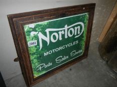 A retro Norton Motorcycles advertising sign in old frame.