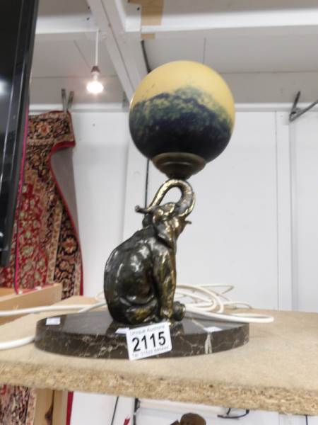 A table lamp of an elephant balancing a ball on trunk.