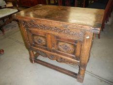 An American carved oak 2 door cupboard with draw leaf top.