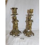 A pair of heavy brass figural candlesticks.