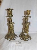 A pair of heavy brass figural candlesticks.