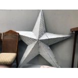 A large painted metal star ornament wall hanging