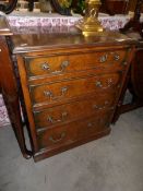 A 20th century walnut veneer 4 drawer chest.