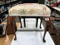 A dressing table stool on pad feet