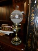 A Victorian brass oil lamp with later shade.
