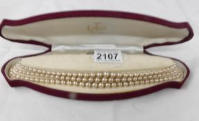 A cased 3 strand pearl necklace with silver clasp.