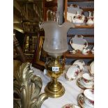 A brass oil lamp complete with shade and chimney.