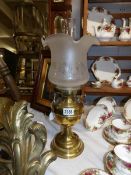 A brass oil lamp complete with shade and chimney.