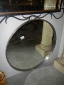 A circular metal framed mirror. approximately 70 cm diameter.