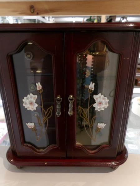 A jewellery cabinet and necklaces.