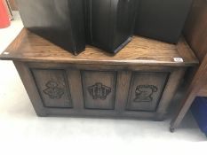 An oak blanket box with carved depictions of knights to front panels
