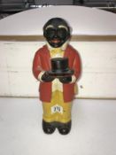 A cast figural money box of an African American door man marked 'Uncle Mose'