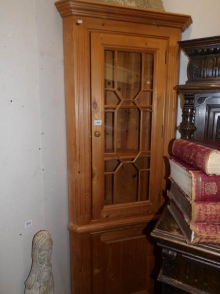 A pine corner cupboard with astragal glazed door.