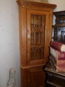 A pine corner cupboard with astragal glazed door.