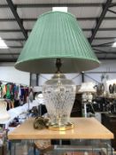 A large cut glass table lamp with brass fittings and green shade