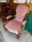 A Victorian mahogany framed chair with pink deep buttoned upholstery.