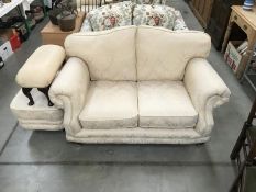 A cream 2 seater settee & 2 foot stools