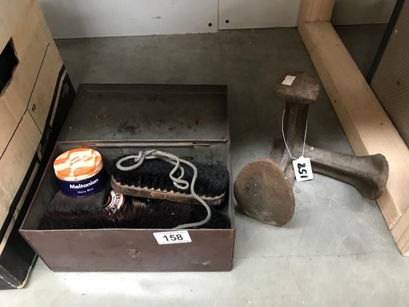 A vintage shoe cleaning tin with contents and a cast iron shoe last