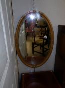 A metal framed oval bevel edged mirror.