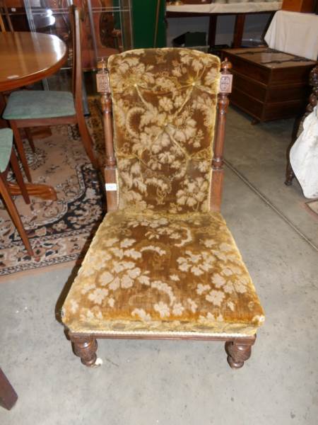 An Edwardian oak upholstered nursing chair.