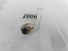 A 9ct gold ring set with black stone (possibly French jet) surrounded by white stones,