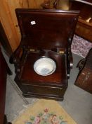 A Victorian mahogany metamorphic chair commode with blue and white pot.