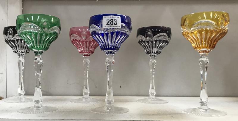 A set of 6 cut glass wine glasses in different colours