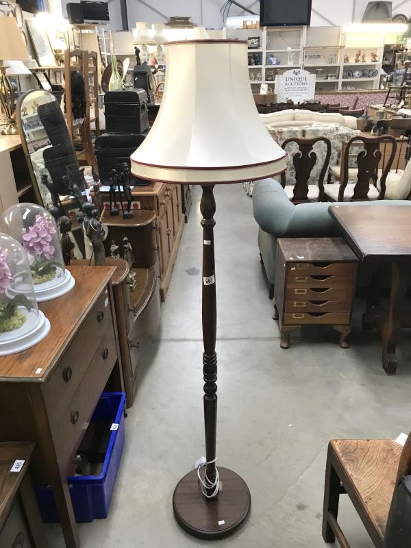 A dark wood standard lamp with shade