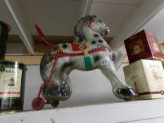 A vintage metal push along toy horse.