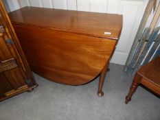 A mahogany drop leaf table on pad feet.