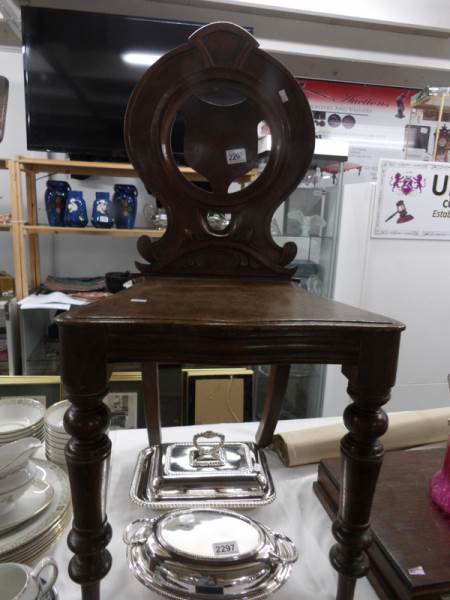 A 19th century oak heraldic hall chair.