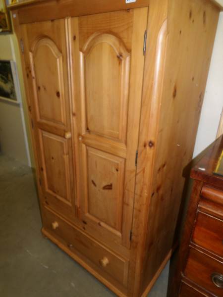 A pine double door and drawer wardrobe.