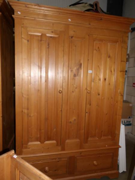 A large pine double wardrobe with drawers.