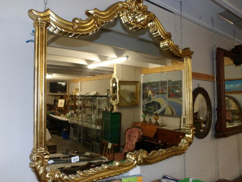 A large gilt framed over mantel mirror, approximately 53.75" x 45".