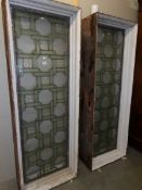 A pair of stained glass windows in box frames, approximately 69.25" high, 24.75" wide and 11" deep.