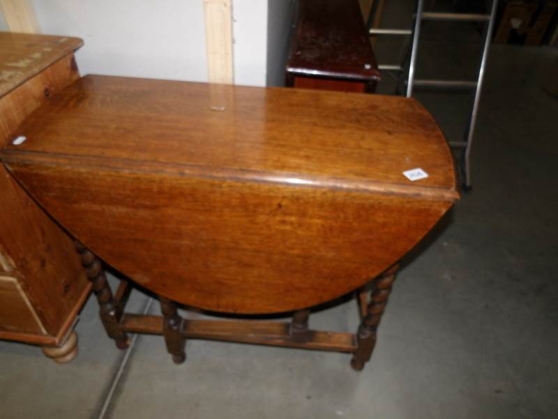 A 1930's oak gate leg table with barley twist legs.