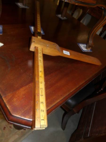 A vintage wooden folding height gauge.