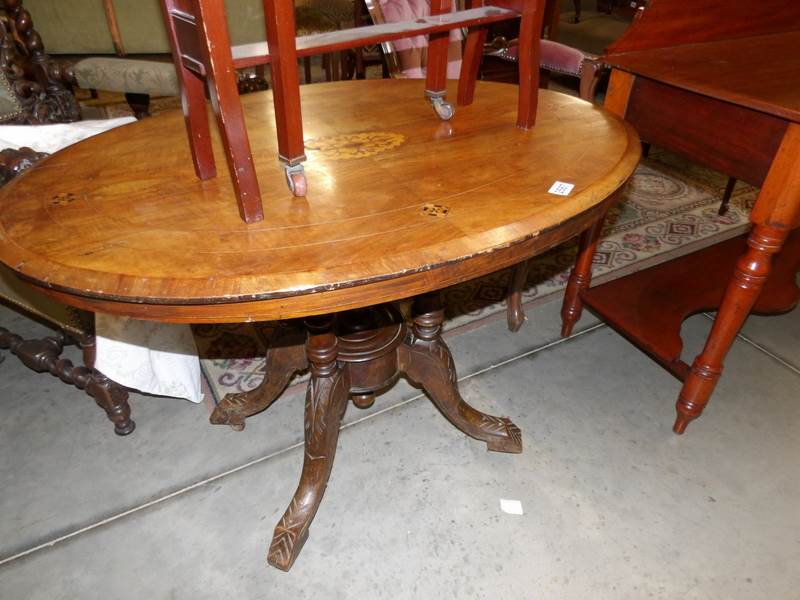 A oval Victorian mahogany inlaid loo table on 'birdcage' base.