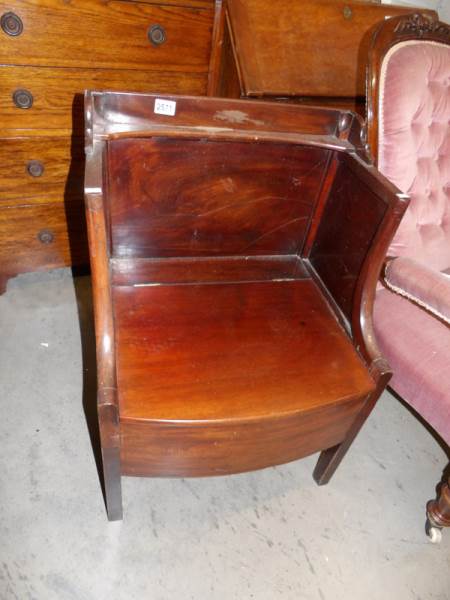 A Victorian mahogany hall chair with storage compartment under seat.