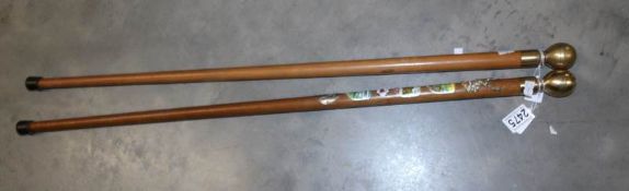 2 brass topped walking sticks with compasses in the tops.