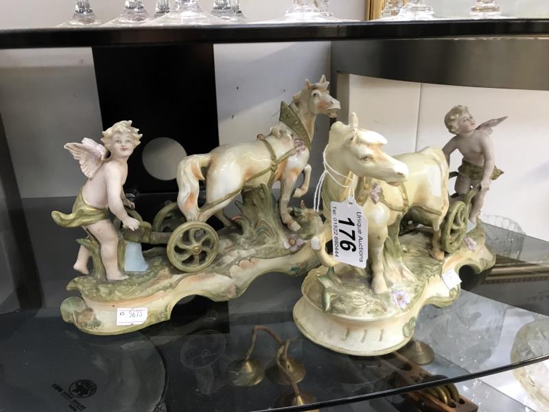A pair of cherub figurines ploughing with horses