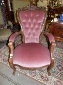 A mahogany framed chair with pink upholstery.