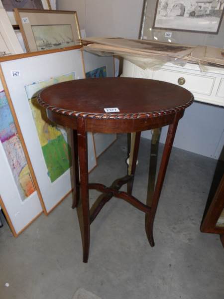 An oval mahogany pie crust edge occasional table.